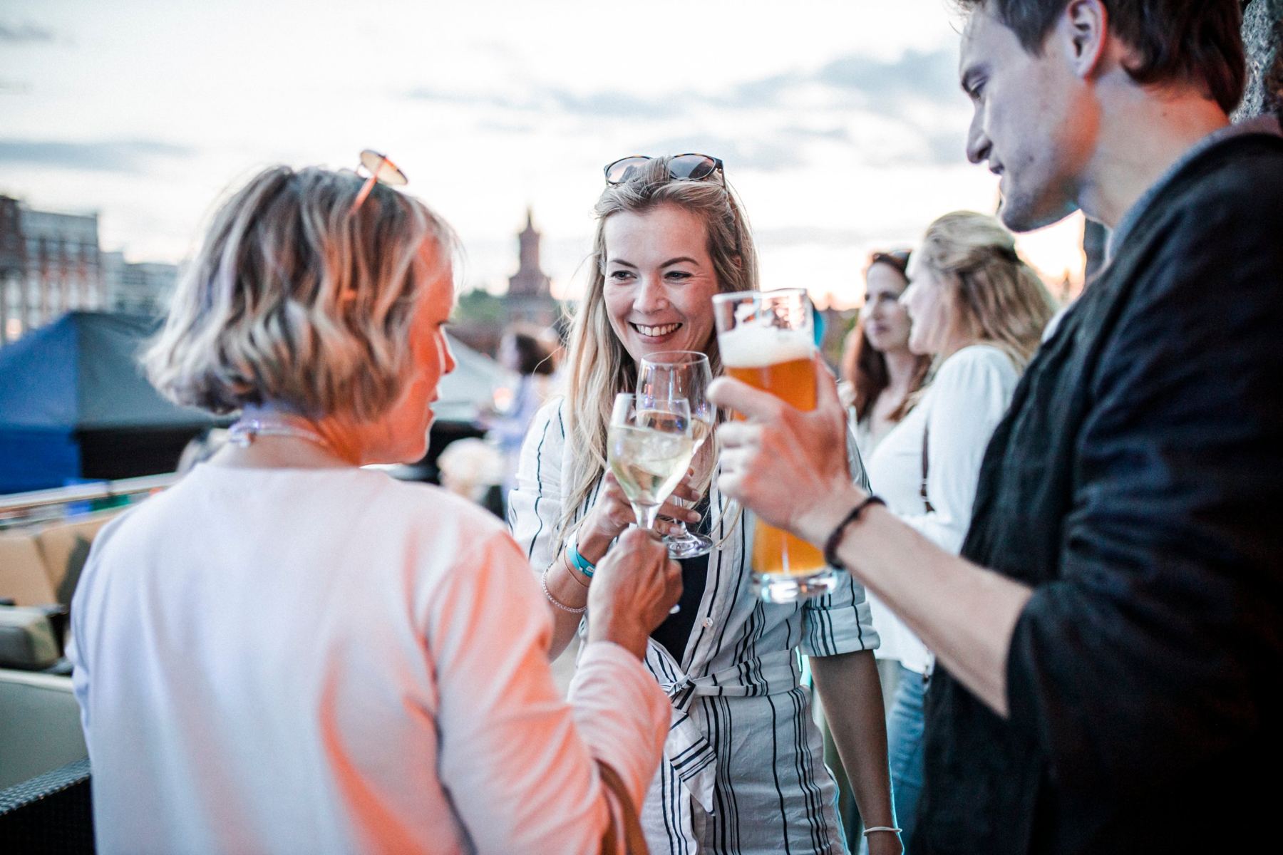 Gäste stoßen bei Sonnenuntergang auf der Terrasse an
