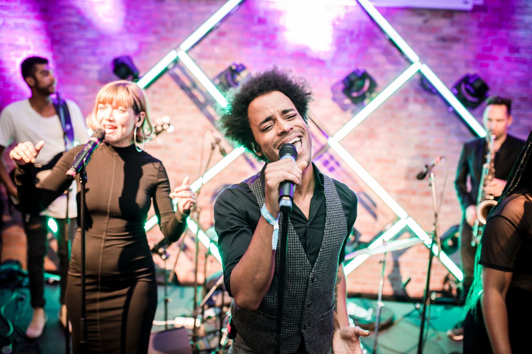 Liveband im Innenraum mit farbiger Lichtinszenierung