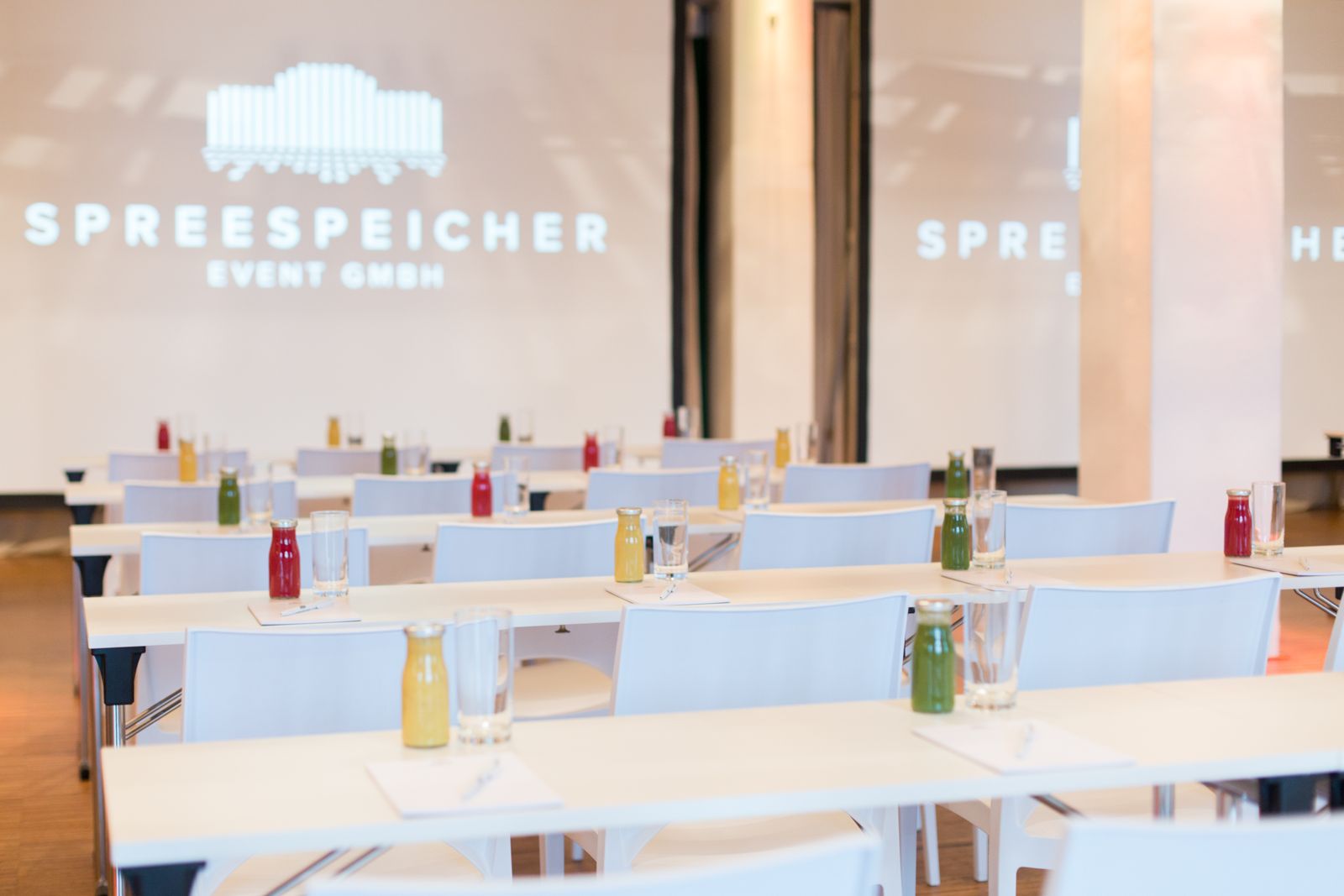 Capitol Yard Golf Lounge im Spreespeicher: Parlamentsbestuhlung mit Saftflaschen und Leinwand Spreespeicher Event GmbH